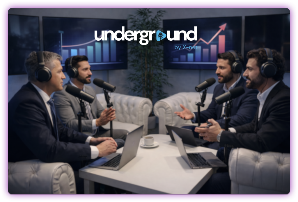Cuatro hombres grabando un podcast profesional en un estudio con micrófonos, auriculares y pantallas con gráficos de crecimiento al fondo.